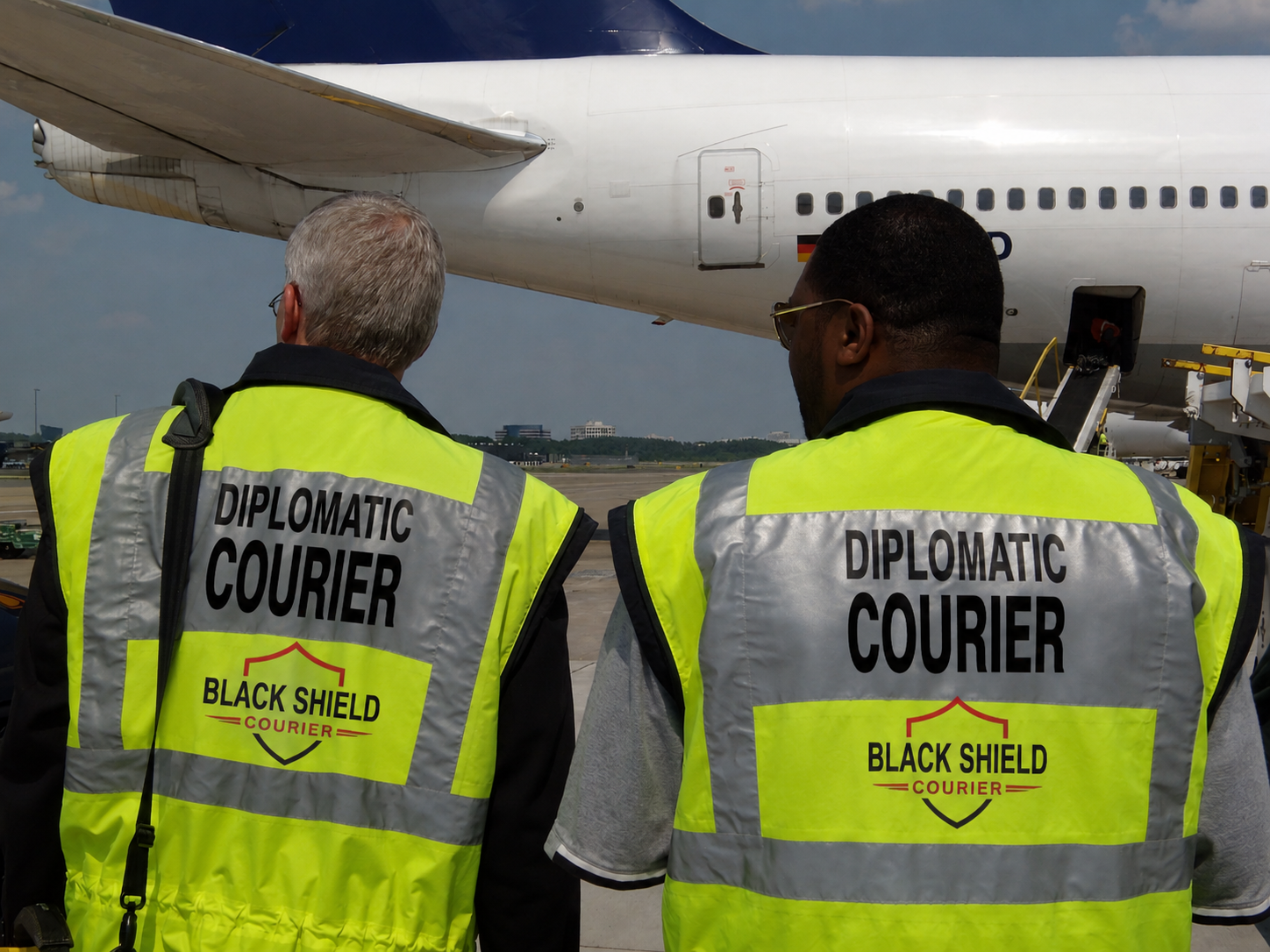 Black Shield diplomatic courier team beside an aircraft